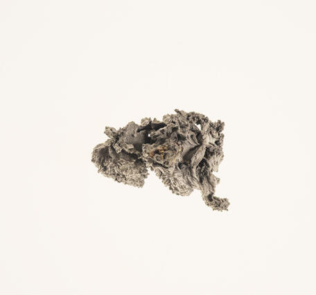 High-definition image of zirconium metal specimen with fine-grained texture and silvery color.