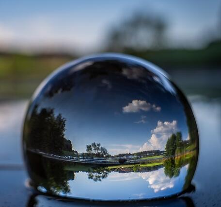 Glass ball showing water scene behind it.