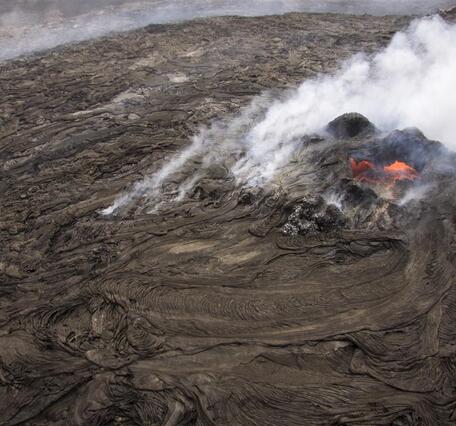 This is a steep aerial view of the small lava pond at the top of th...