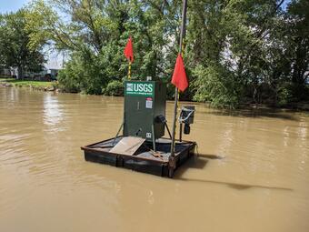 A fully constructed bait delivery platform floating on water.