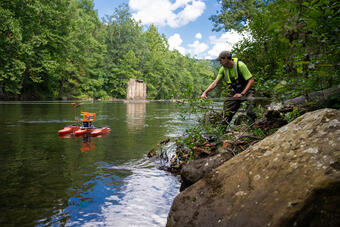 Eric Boyd pulls an Acoustic Doppler Current Profiler across a river.