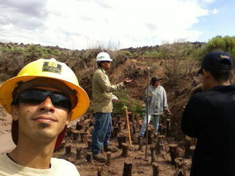 A man in safety gear takes a picture of himself with his crew.