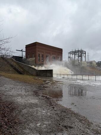 Floodwaters at high flow below historic brick dam