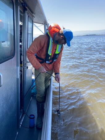 man putting line in water