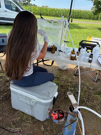 Scientist collecting groundwater samples in a sealed workspace while in the field
