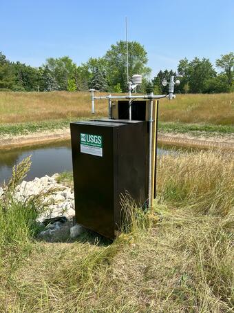 Constructed stormwater wetland upland native vegetation surrounding a USGS self-contained, solar-powered, monitoring station 