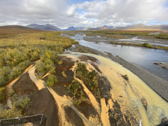 pale orange river flowing into a clear blue river.