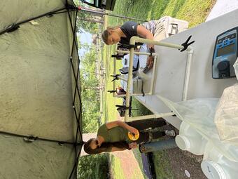 Two USGS Scientists drawing water samples from a well to prepare them for the lab