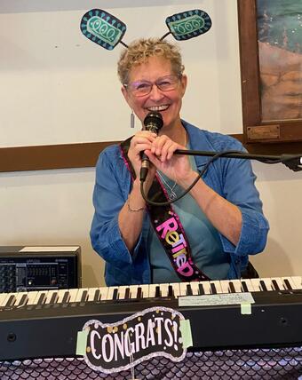 Gael Kurath singing and playing the piano at her retirement party