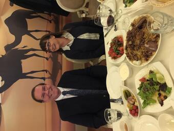 Man and woman siting at a dinner table in front of plates of food