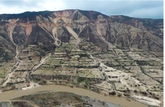 buildings below a mountainside that have been partially buried by mud