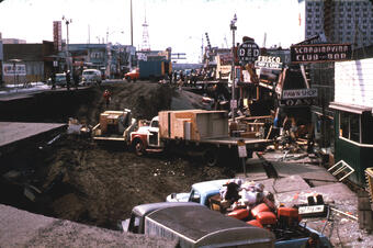 Street is now giant whole with large trucks inside, with people working to clear the area. Debris everywhere. 
