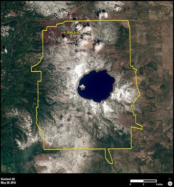 Image shows a satellite image of Crater Lake with the National Park boundary in yellow.