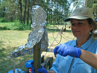 Scientist Uses a Syringe to Withdraw Water from a Core