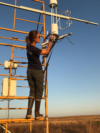 Scientist adjusts equipment mounted on tower at the Suisun Marsh in California.