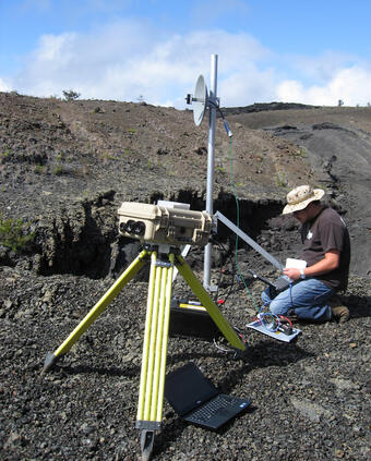 Color photograph showing person and instrument measuring volcanic gas