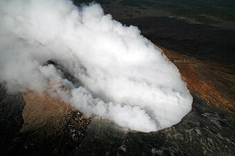 Color photograph showing a volcanic crater emitting volcanic gases