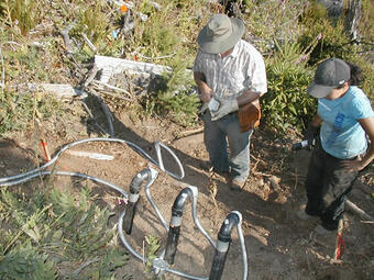 Employees setting up monitoring devices on the hillside of Knife Ridge