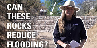 Text: Can these rocks reduce flooding? with an image of Laura Norman and a two men standing on a gabion in the background.