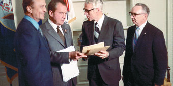Three men surrounding President Nixon