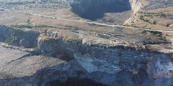 Color photograph of road and crater