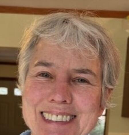 Woman with short blond hair smiling at camera 