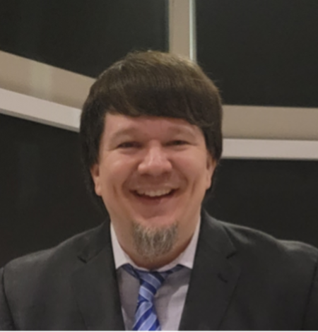 brunette smiling man with some facial hair and a suit and tie