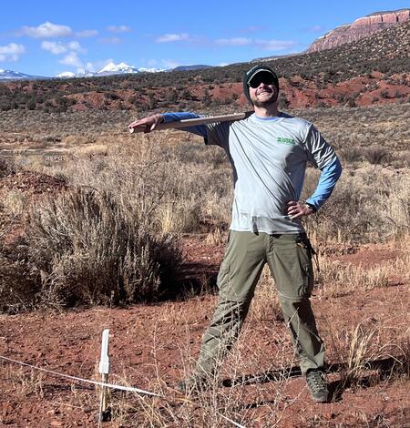 Jackson Sharp (USGS) at site visit with mountains in background