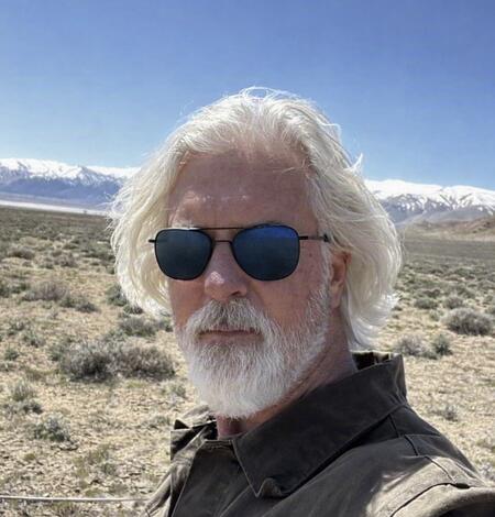 White man with white hair and black sunglasses