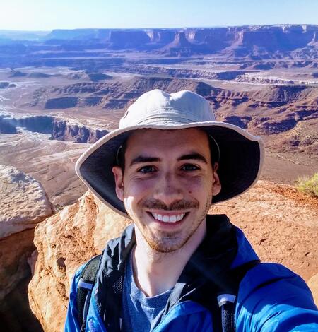 man standing in front of a large canyon