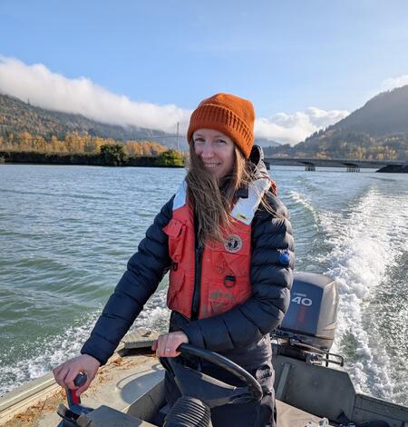 woman driving USGS boat in orange beanie