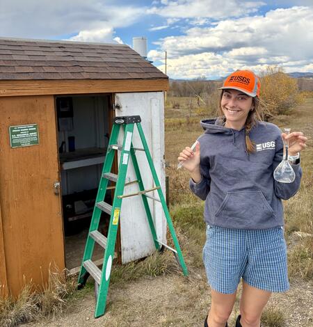 Photo of USGS employee holding a beaker 