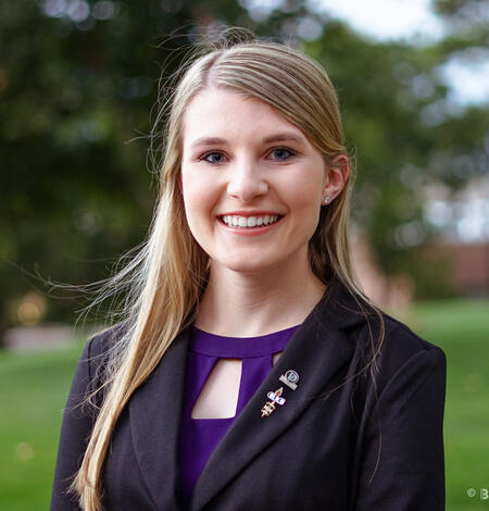 Portrait image of ​USGS employee Morgan Schachterle​, with a blurred green landscape in the background