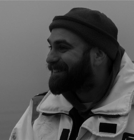 Black and white image of Neel Hodgkinson in a float coat.