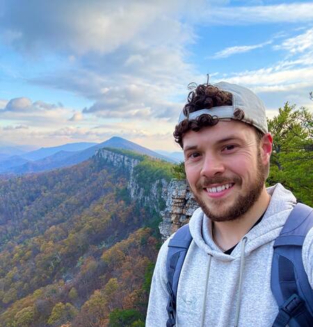 Image of Nicholas Giro with a mountain range behind him for his staff profile.