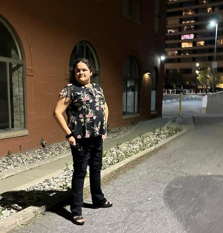 Women in front of building at night.
