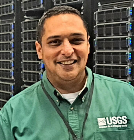 Man smiling wearing a green USGS shirt
