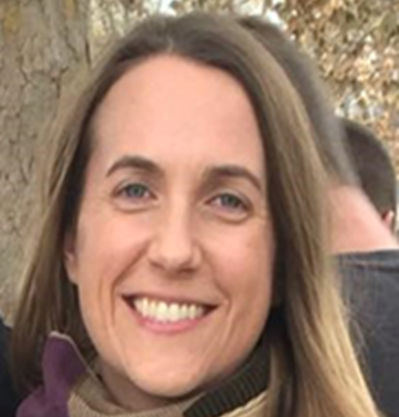 Photograph of Sarah E Peterson wearing a scarf with trees in the background