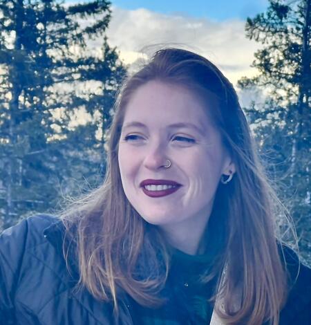 Woman smiling with trees in the background
