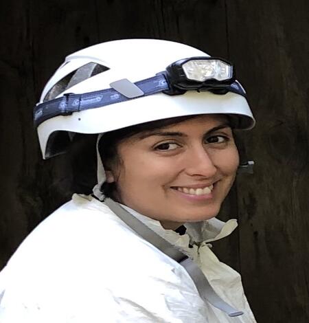 Ariel Leon wearing a white helmet with a head lamp and a white tyvek suit.