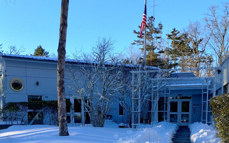 building with lots of snow on the ground and a shoveled path to the door