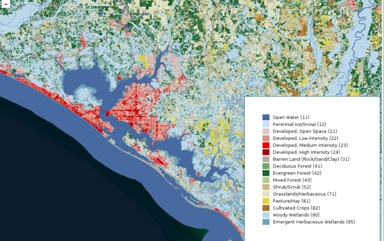 A map of a coastline with various shades of greens, browns, blues and reds on the land