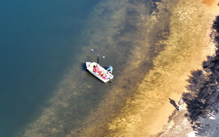 aerial view of small boat near shoreline of pond