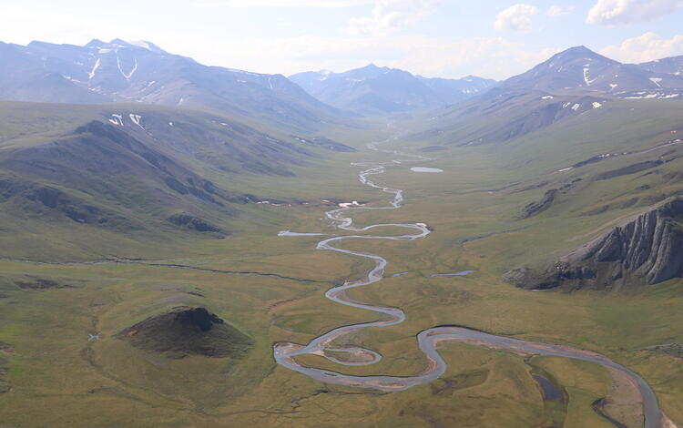 meandering river with mountains on each side