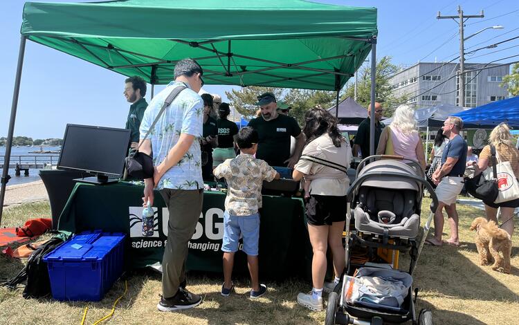 a family visiting a USGS booth outside