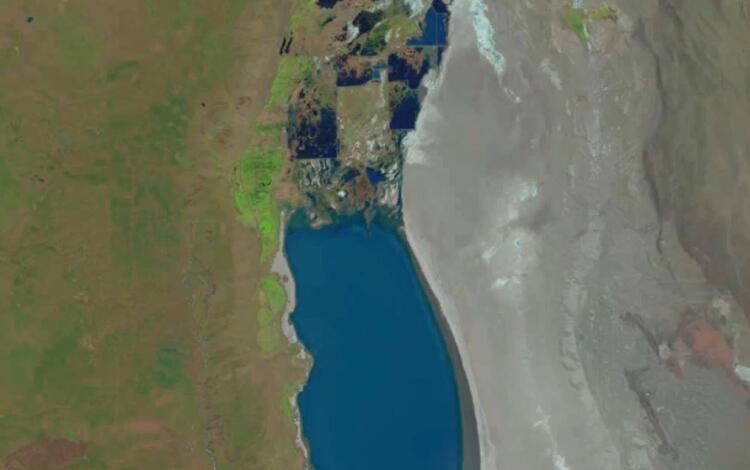 blue oblong lake surface surrounded by arid land