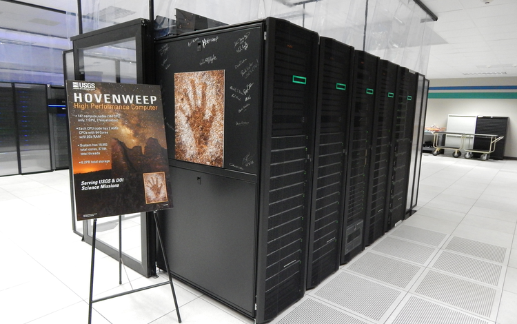 Hovenweep Supercomputer at EROS Data center. Sign next to 5 computer racks reads "Hovenweep" and negative hand relief