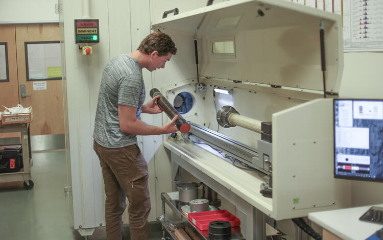 Scientist placing a sediment core in the rotating x-ray computed tomography system