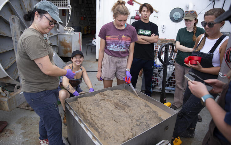 Scientists removing top water from a box core sample during the Hawaii Abyssal Nodules Expedition