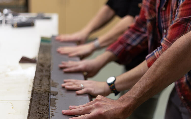 Scientists separating a sediment core split lengthwise